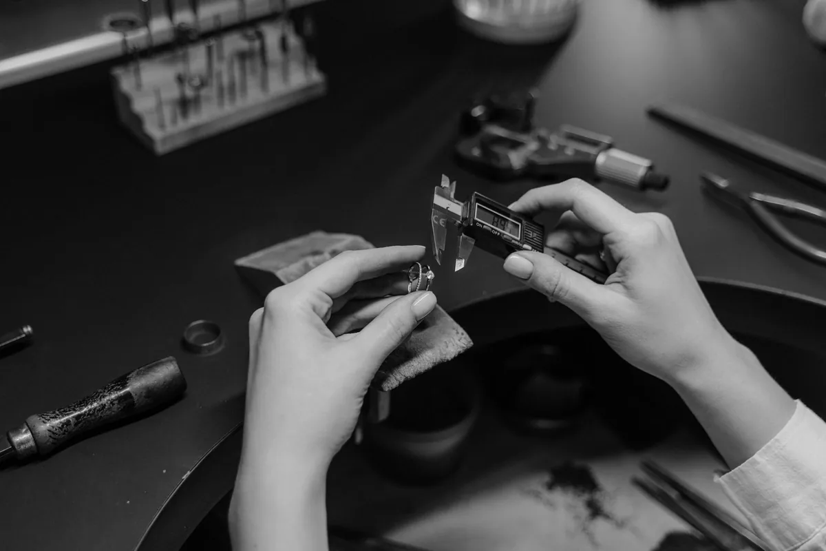 ruce měří prsten digitálním posuvným měřidlem